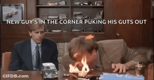 A Man Is Sitting At A Desk With A Toy Car On Fire . GIF