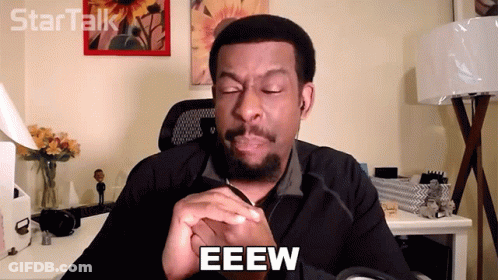 A Man Is Sitting At A Desk With His Eyes Closed And The Word Eeew Written On His Face GIF