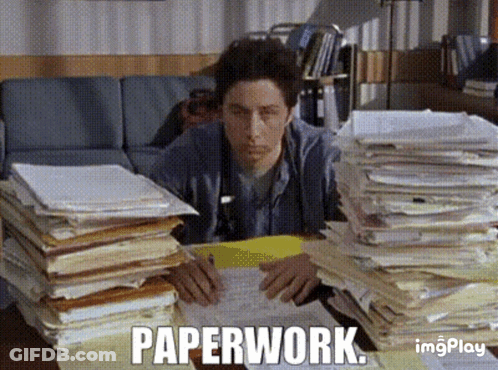 A Man Is Sitting At A Desk With Stacks Of Papers And The Word Paperwork Written On The Screen GIF