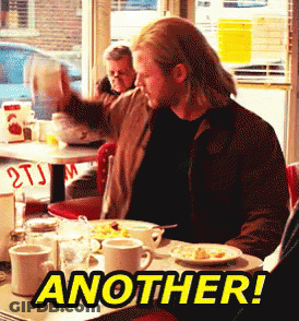 A Man Is Sitting At A Diner Table With Another Written On The Table GIF