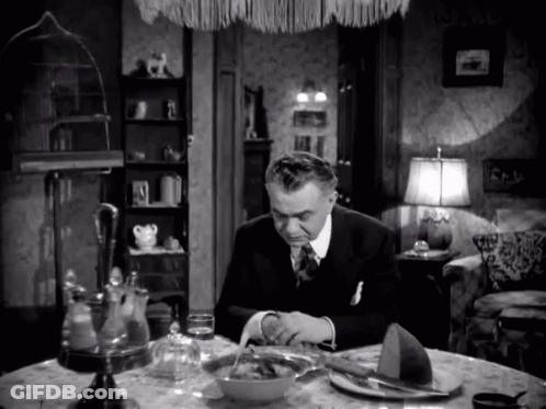 A Man Is Sitting At A Table With A Bowl Of Food GIF