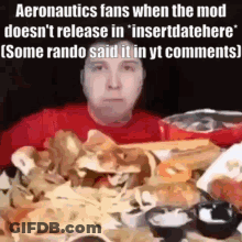 A Man Is Sitting At A Table With A Bunch Of Food On It . GIF