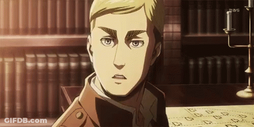 A Man Is Sitting At A Table With A Candle In Front Of A Bookshelf . GIF