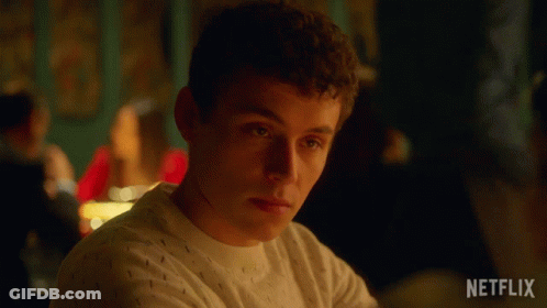 A Man Is Sitting At A Table With A Netflix Logo On The Bottom Right GIF