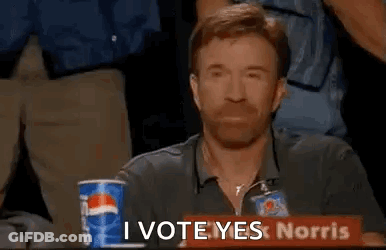 A Man Is Sitting At A Table With A Pepsi Cup And A Sign That Says `` I Vote Yeslorris '' . GIF