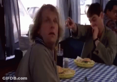 A Man Is Sitting At A Table With A Plate Of Food GIF