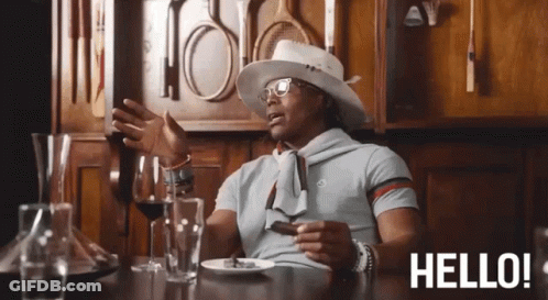 A Man Is Sitting At A Table With A Plate Of Food And A Glass Of Wine And The Words Hello Behind Him GIF