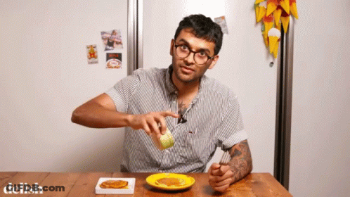 A Man Is Sitting At A Table With A Plate Of Food And The Word Delish On The Bottom Right GIF