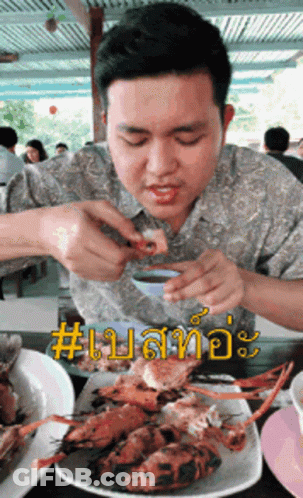 A Man Is Sitting At A Table With A Plate Of Food In Front Of Him And The Word # On The Bottom Right GIF