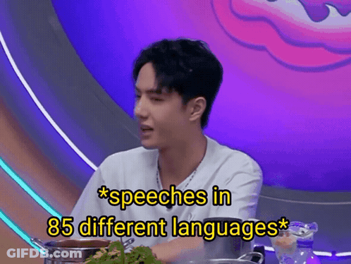 A Man Is Sitting At A Table With A Pot Of Food And The Words Speeches In 85 Different Languages Above Him GIF