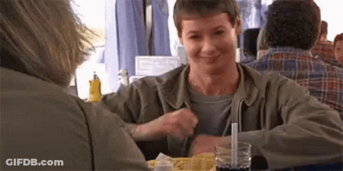 A Man Is Sitting At A Table With A Straw In His Glass . GIF