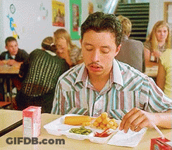 A Man Is Sitting At A Table With A Tray Of Food And A Carton Of Orange Juice GIF