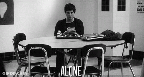A Man Is Sitting At A Table With A Tray Of Food And A Laptop . GIF