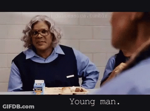 A Man Is Sitting At A Table With A Tray Of Food And A Milk Carton That Says ' Young Man ' On It GIF