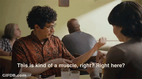 A Man Is Sitting At A Table With A Woman And Says " This Is Kind Of A Muscle Right ? Right Here " GIF