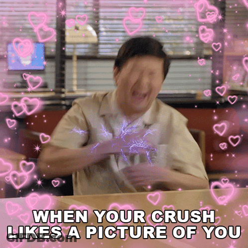 A Man Is Sitting At A Table With Hearts Around Him And The Caption Says When Your Crush Likes A Picture Of You GIF