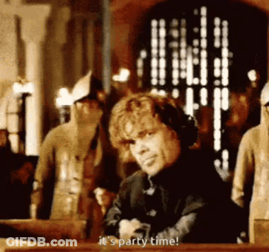 A Man Is Sitting At A Table With His Arms Crossed And Saying `` It 'S Party Time '' . GIF