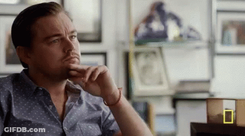 Man Sitting At Table With Hand On Chin GIF