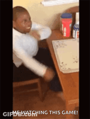A Man Is Sitting At A Table With His Hands On His Head And The Words `` Me Watching This Game '' Written On The Bottom . GIF