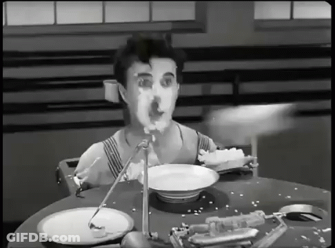 A Man Is Sitting At A Table With Plates And A Bowl Of Food GIF