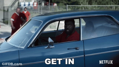 A Man Is Sitting In A Blue Car That Says Get In On The Side GIF
