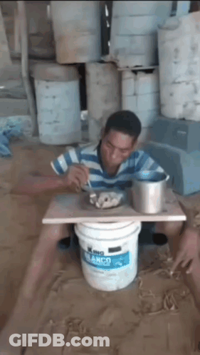 A Man Is Sitting In A Bucket Of King Blanco Paint GIF