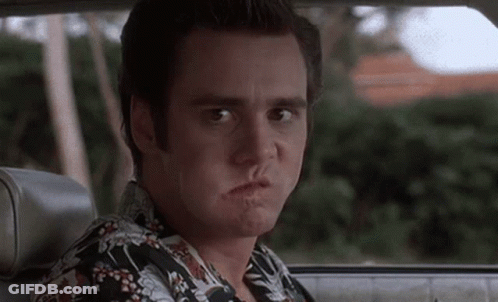 A Man Is Sitting In A Car Making A Funny Face . GIF