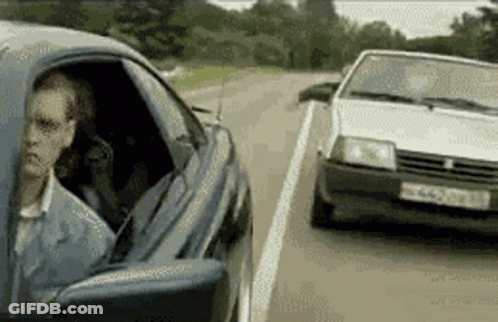 A Man Is Sitting In A Car Next To A White Car With A License Plate That Starts With Nc GIF
