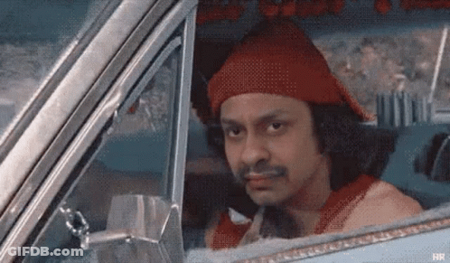 A Man Is Sitting In A Car Wearing A Red Hat . GIF