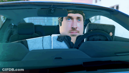 A Man Is Sitting In A Car With A Laptop On His Lap GIF