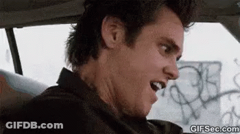A Man Is Sitting In A Car With His Mouth Open . GIF
