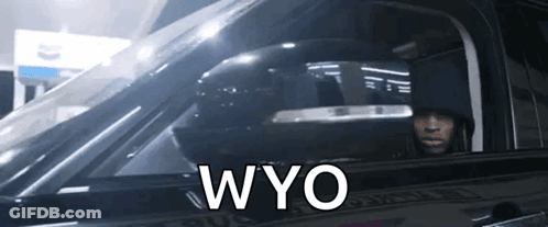 A Man Is Sitting In A Car With The Word Wyo Written On The Side GIF