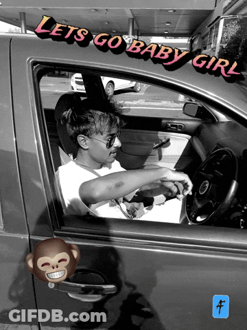 A Man Is Sitting In A Car With The Words Let 'S Go Baby Girl Written On The Side GIF
