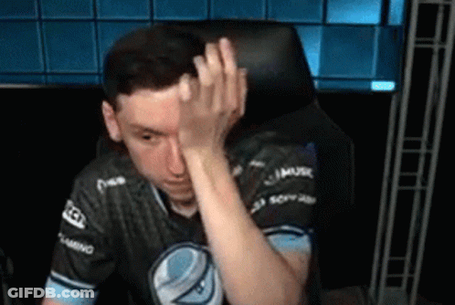 A Man Is Sitting In A Chair And Covering His Face With His Hand . GIF