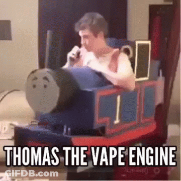A Man Is Sitting In A Chair Dressed As Thomas The Tank Engine And Smoking A Cigarette . GIF