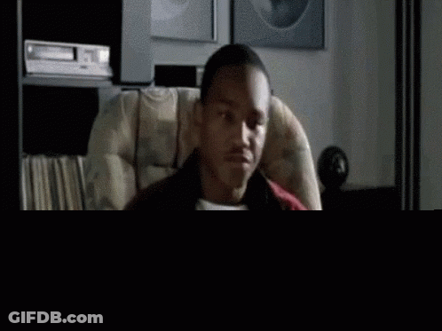 A Man Is Sitting In A Chair Eating A Bag Of Potato Chips . GIF
