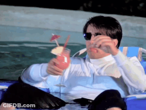 A Man Is Sitting In A Chair Holding A Drink In His Hand GIF