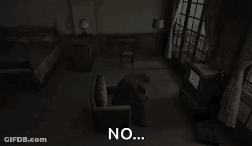 A Man Is Sitting In A Chair In A Dark Room With The Words `` No '' Written On The Screen . GIF