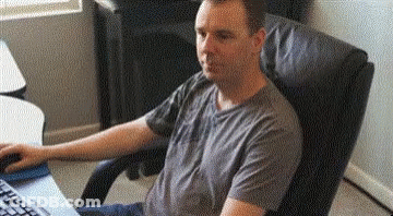 A Man Is Sitting In A Chair In Front Of A Computer Keyboard . GIF