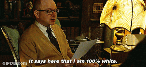 A Man Is Sitting In A Chair Reading A Piece Of Paper And Says It Says Here That I Am 100 % White GIF