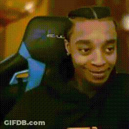 A Man Is Sitting In A Chair With A Blue Headrest And Smiling . GIF