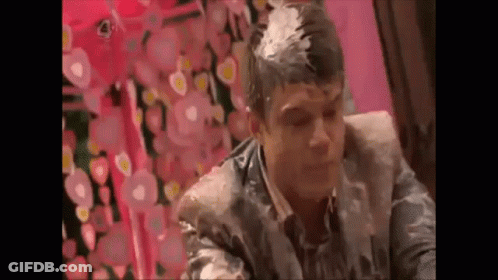 A Man Is Sitting In A Chair With A Lot Of Foam On His Head . GIF