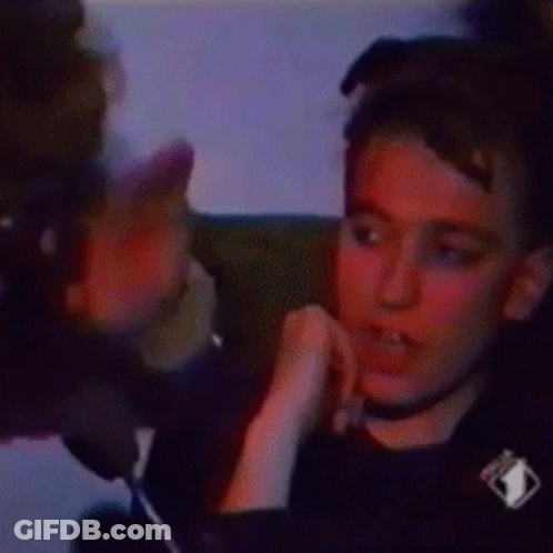 A Man Is Sitting In A Chair With A Tv Icon On His Shirt GIF