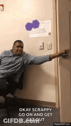 A Man Is Sitting In A Chair With His Arm Outstretched And Says Okay Scrappy Go On And Get Out .. GIF
