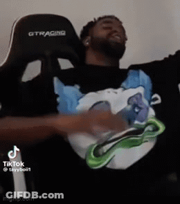A Man Is Sitting In A Chair With His Arms Outstretched And Wearing A Black Shirt With A Picture Of A Dog On It GIF