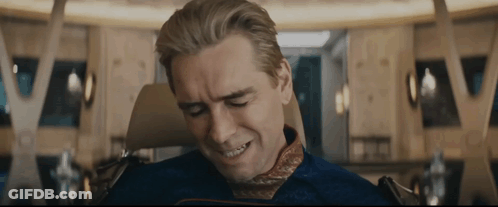 A Man Is Sitting In A Chair With His Eyes Closed And A Smile On His Face . GIF