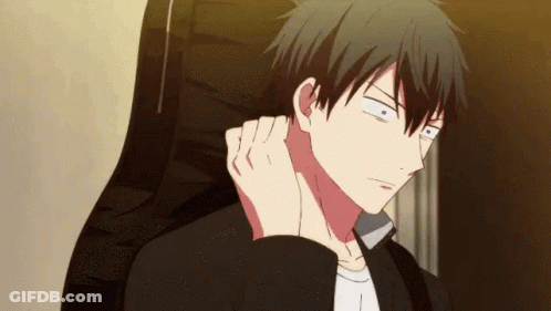A Man Is Sitting In A Chair With His Hand On His Ear And Looking At The Camera . GIF