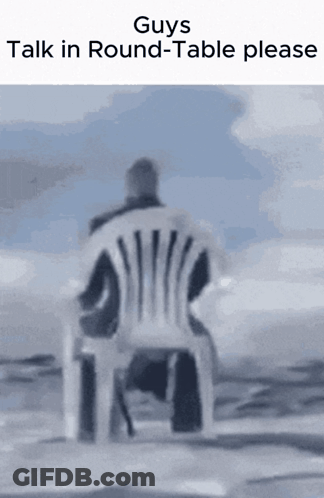 A Man Is Sitting In A Chair With The Words " Guys Talk In Round-Table Please " Above Him GIF