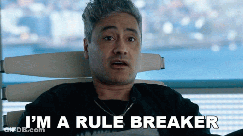 A Man Is Sitting In A Chair With The Words I 'M A Rule Breaker Above Him GIF