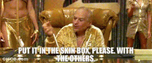 A Man Is Sitting In A Chair With The Words Put It In The Skin Box Please With The Others Behind Him GIF
